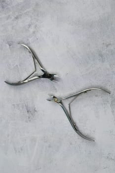A set of cosmetic tools for manicure and pedicure stand on a black background. scissors and tongs. Top views