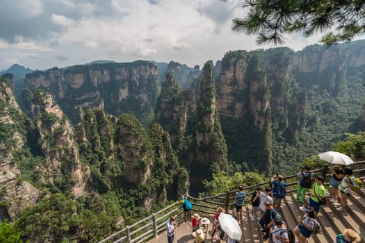 Zhangjiajie, China - August 2019 : Tourists taking pictures on mobile phones on the  Enchanting terrace viewpoint, Avatar mountains nature park