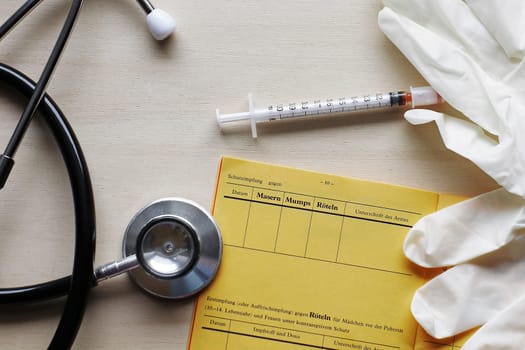 Vaccinations against measles, mumps and rubella with vaccination card and syringe