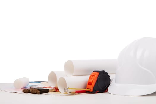 Architectural blueprints, construction hard hat, color palette guide, painting accessories on white background.  Architect workplace. Engineering tools. Concept of construction or design office