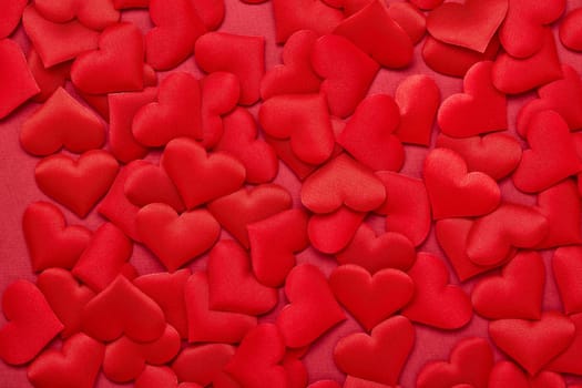 Valentine background from red silk hearts. Valentine's Day card. Top view with copy space. Design element for romantic greeting card, invitation. Women's Day. Hearts background. Wedding day.