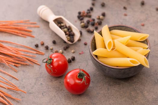 Mix of pasta made from wheat semolina, quinoa and azuki beans on a brown textured background, ingredients italian food