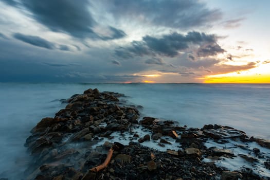 Sea sunset after sunset, in the foreground a breakwater of stones