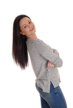 A lovely smiling young woman standing in the studio bending backwards.with her long brunette hair, isolated for white background.