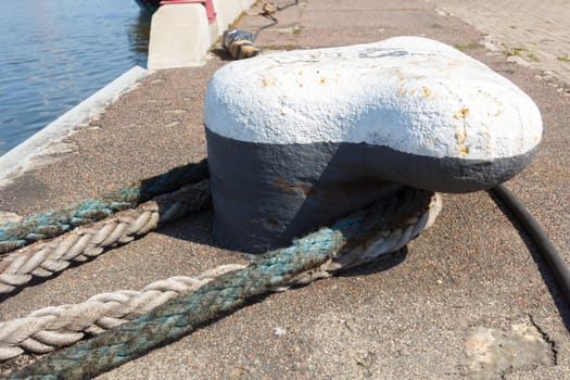 Ship mooring rope moored on the bollard.