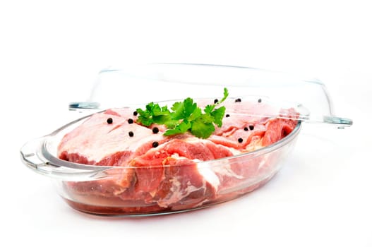 Fresh red meat with seasoning in glass pan ready to cook