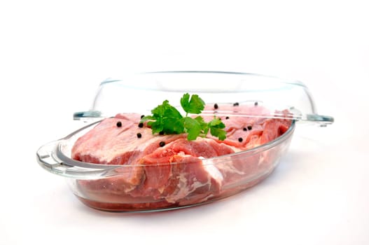 Fresh red meat with seasoning in glass pan ready to cook