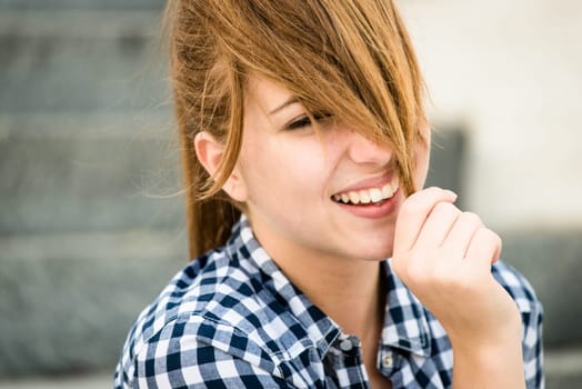 Teenager girl playing with her hair - outdoor on street