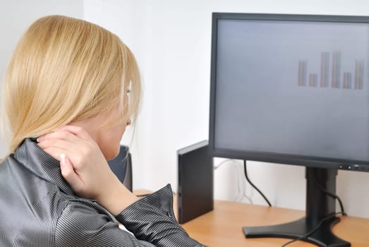 Business woman with neck pain sitting at computer
