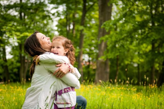Small girl enjoying life with her mother outdoor in nature