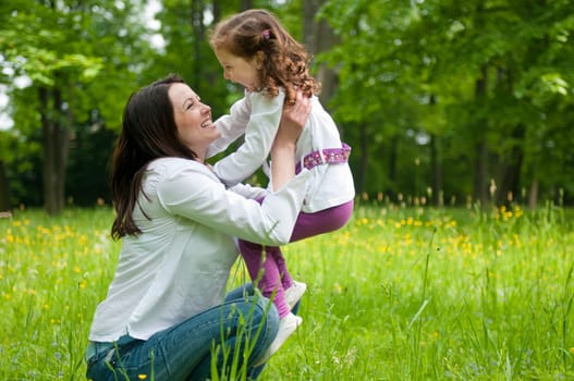 Small girl enjoying life with her mother outdoors