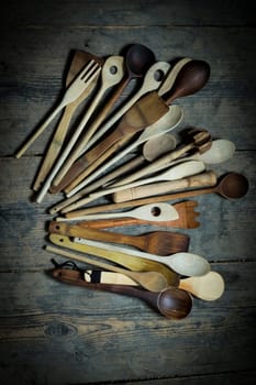 different wooden spoons on wooden background, topview