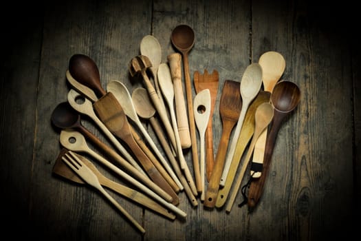 different wooden spoons on wooden background, topview
