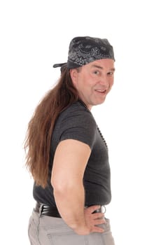 A smiling middle age man in a black sweater standing with his hands.on his hips and a head scarf, isolated for white background.