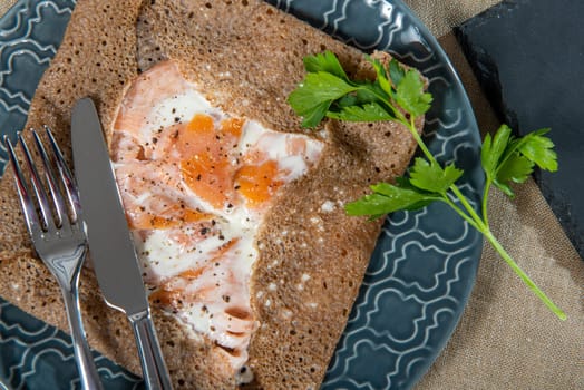 homemade Breton crepe with egg in blue plate