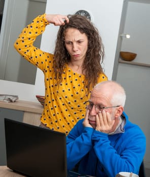Young woman and senior man have problem with a laptop computer