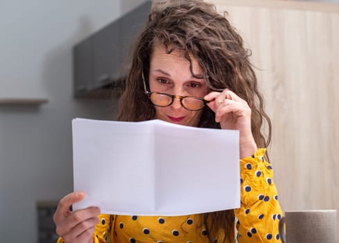 a serious woman looking at received mail at home