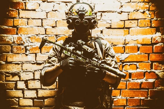 Army special forces tactical group fighter in cqb mission, using radio headset, looking through four lens night-vision, thermal imaging device on helmet, armed small submachine gun with silencer