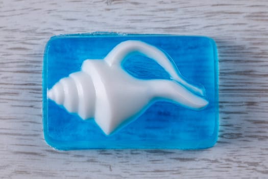 Glycerin base soap handmade with a white shell on a blue transparent base lying on the table