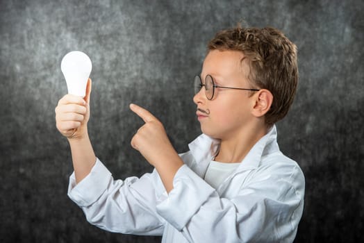 cute smiling child boy with a light bulb