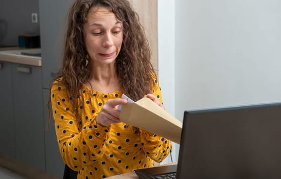 a young woman looking at received mail at home