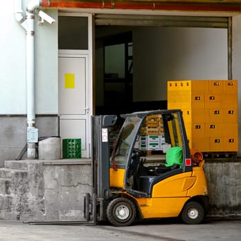 Commercial forklift vehicle in front of warehouse.
