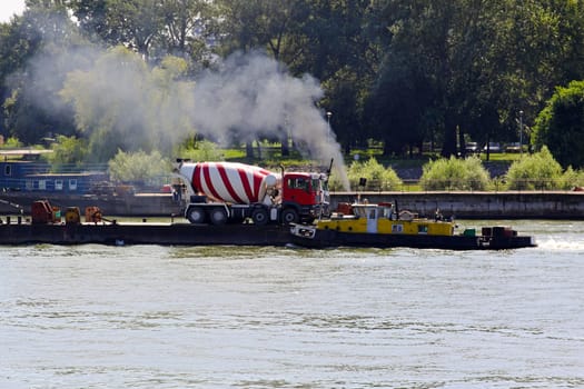 Concrete mixer truck delivery at river barge.