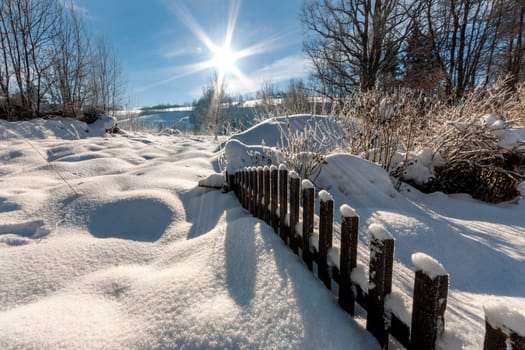 Orlicke Mountains - fence covered with snow with sun and blue sky. High quality photo
