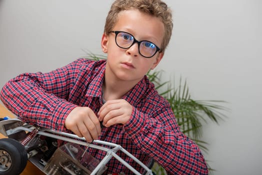 a little boy repairing a model radio-controlled car at home