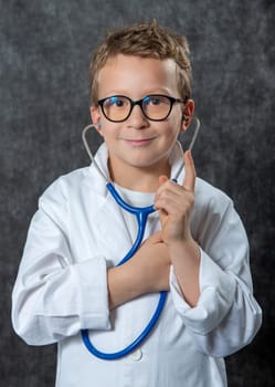 Cute kid boy wear medical uniform playing doctor, a portrait