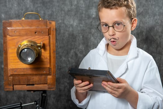 cheerful boy retro photographer with a vintage wooden camera