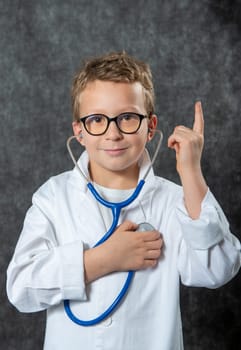 Cute kid boy wear medical uniform playing doctor, a portrait