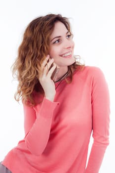 Portrait of cute joyful woman with trendy hairstyle wearing basic t-shirt talking on mobile phone isolated over white background.