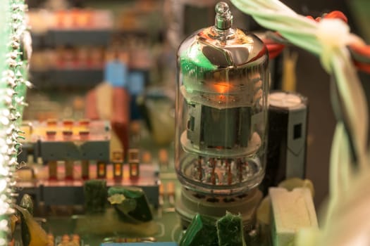 Electrical assembly with glowing tube on a circuit board with electrical components and cables