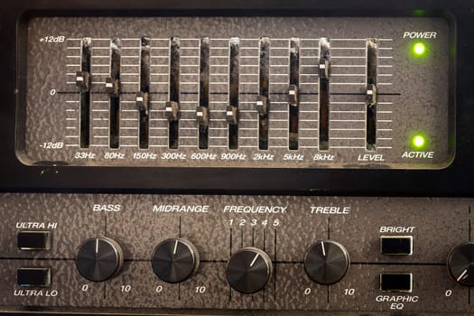 Old black dusty controls of an audio equalizer from a guitar amplifier