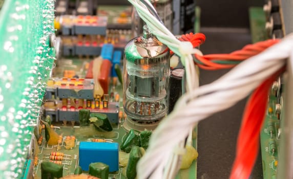 Electrical assembly with glowing tube on a circuit board with electrical components and cables