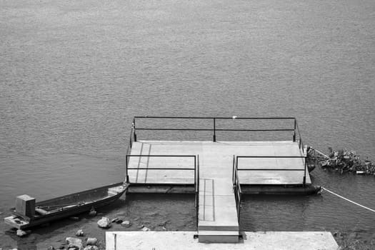 boat moor floating  platform walkway river sunny day calm water black white