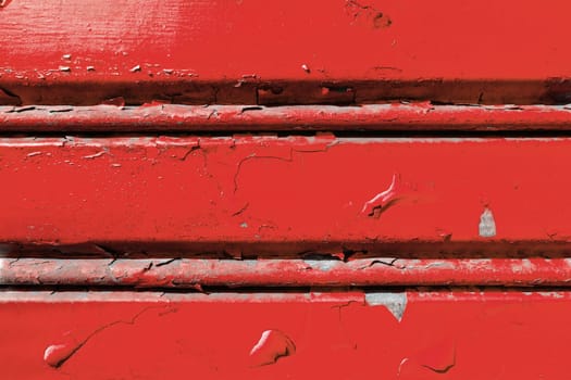 Background of old metal sheet with peel paint texture surface. Painted metal roller shutters door with peeling paint dirty red hue. Grungy background texture.