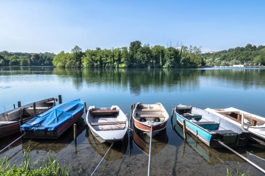 Small boats moored along the shore of the Adda river. Trezzo sull'Adda (MILAN), ITALY - May 31, 2019.