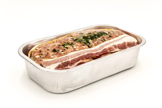 Meatloaf ready to bake in its aluminum tray profile view isolated on white background