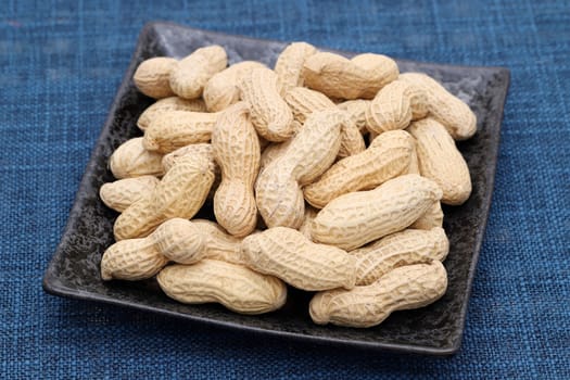 Organic peanuts in shell in a dish on table