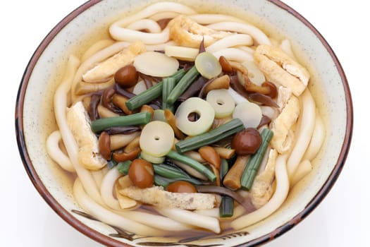 Japanese udon noodles in a ceramic bowl on white background