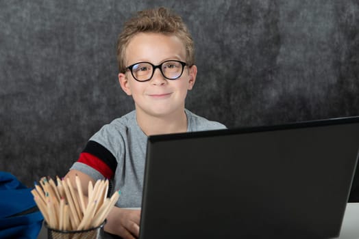 serious boy sitting with a laptop computer