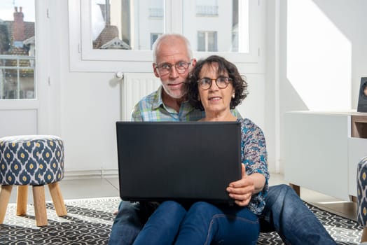 Couple senior using computer laptop at home for online shopping, surfing internet