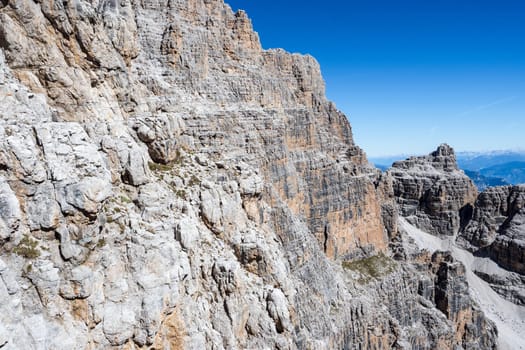 Fixed-rope Route, climbing a via ferrata route. Italian Alps. Mountain tourism in the Dolomites. Region Brenta, Italy.
