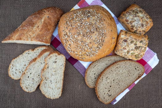 Fresh bread on table, top view. Baked dark bread and sliced bread.