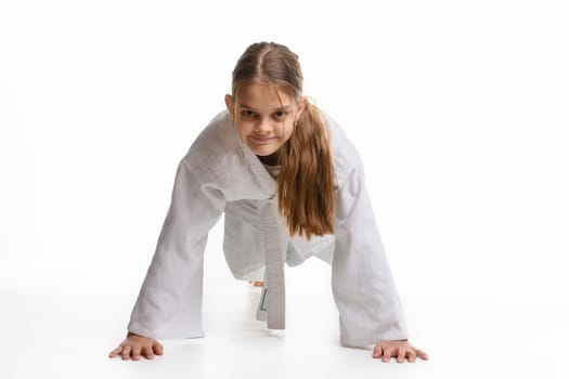 Girl push-UPS from the floor in a sports keikogi