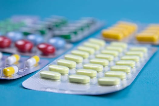 Lemon, ginger, and chapel against multi-colored tablets. The concept of choosing a healthy diet versus taking medication. Top views with clear space