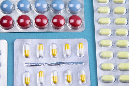 Lemon, ginger, and chapel against multi-colored tablets. The concept of choosing a healthy diet versus taking medication. Top views with clear space
