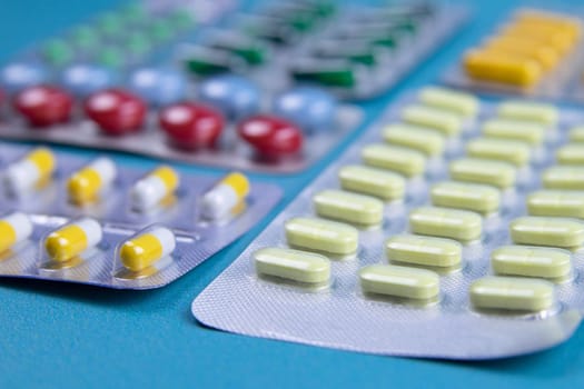 Lemon, ginger, and chapel against multi-colored tablets. The concept of choosing a healthy diet versus taking medication. Top views with clear space